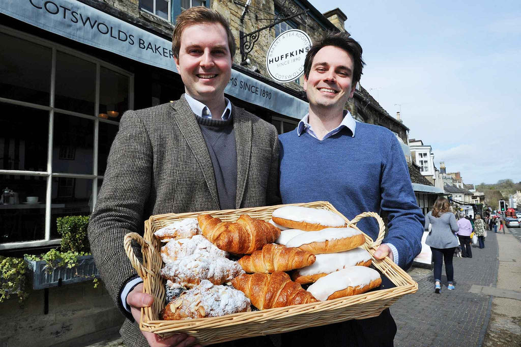 Joshua and Jacob Taee holding a basket of freshly baked pastries outside Huffkins bakery in Burford, Cotswolds